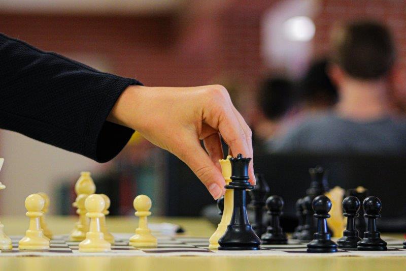 a person is moving a chess piece